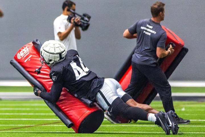 Raiders linebacker K'Lavon Chaisson (44) takes down a tackling dummy during practice at the Int ...