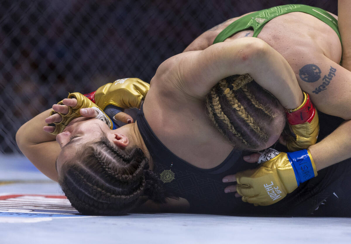 Women's flyweight title fighter Alexa Grasso gets a glove to the face as she holds the head of ...