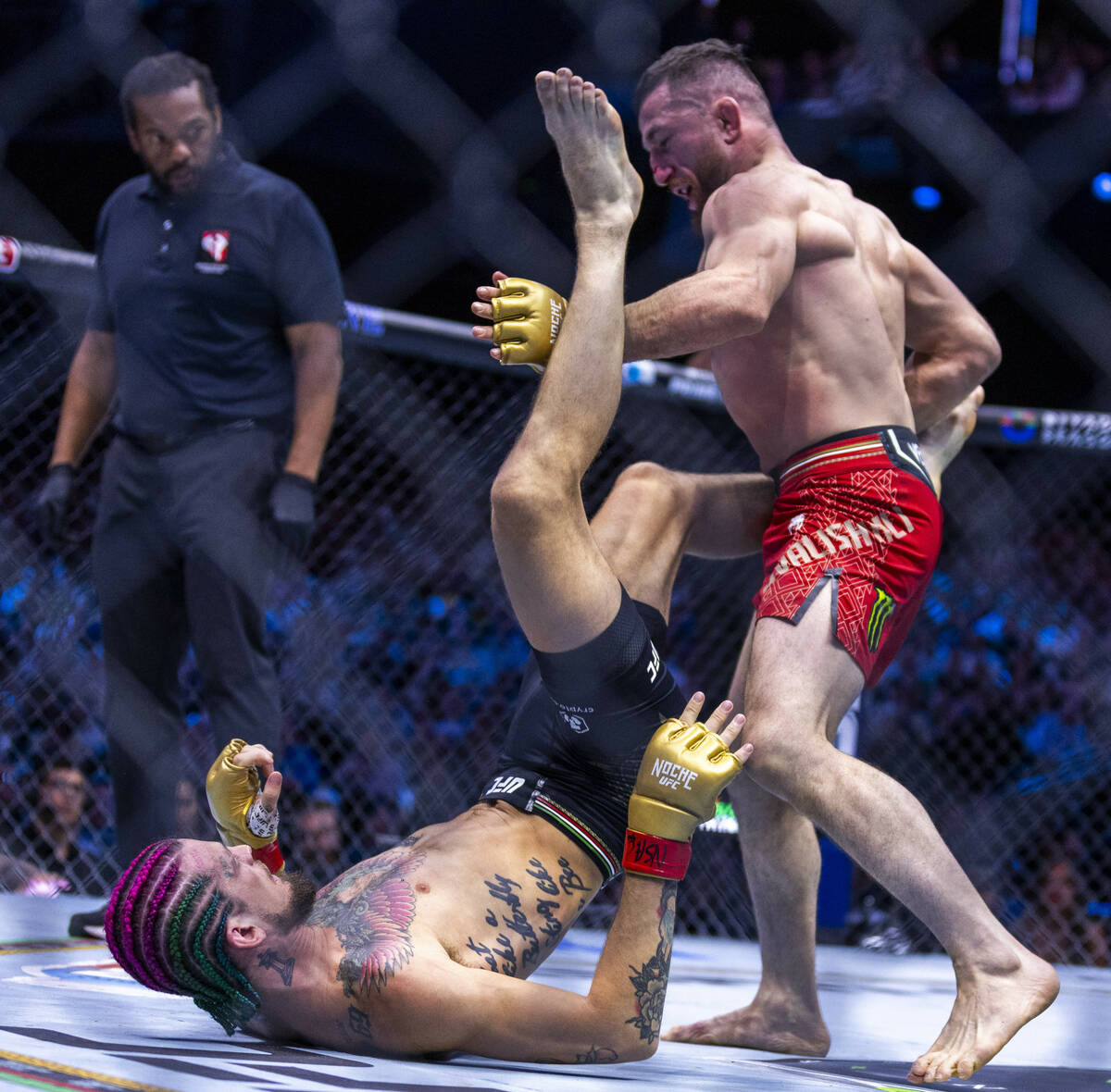 Sean O'Malley attempts to kick away Merab Dvalishvili above him in their bantamweight title fig ...