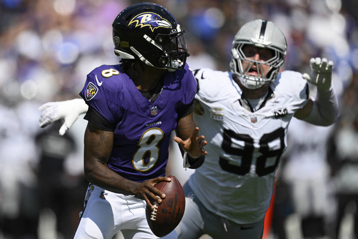 Las Vegas Raiders defensive end Maxx Crosby (98) chases after Baltimore Ravens quarterback Lama ...