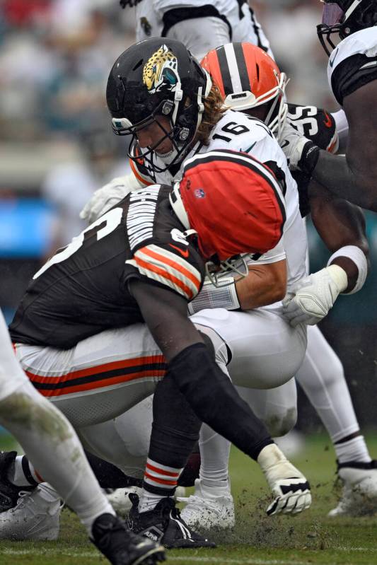 Jacksonville Jaguars quarterback Trevor Lawrence (16) is sacked by Cleveland Browns linebacker ...