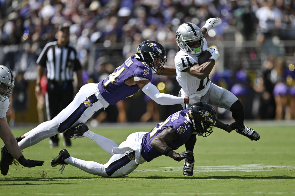 Las Vegas Raiders wide receiver Tre Tucker (11) runs with the ball after catching a pass and is ...