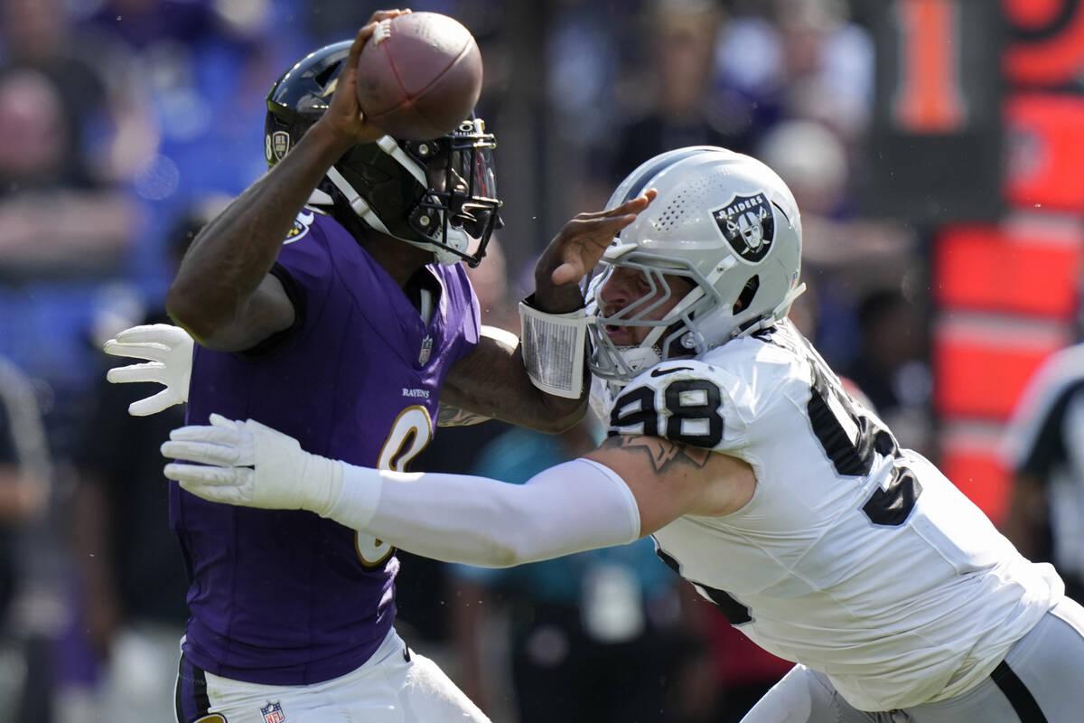 Las Vegas Raiders defensive end Maxx Crosby (98) sacks Baltimore Ravens quarterback Lamar Jacks ...