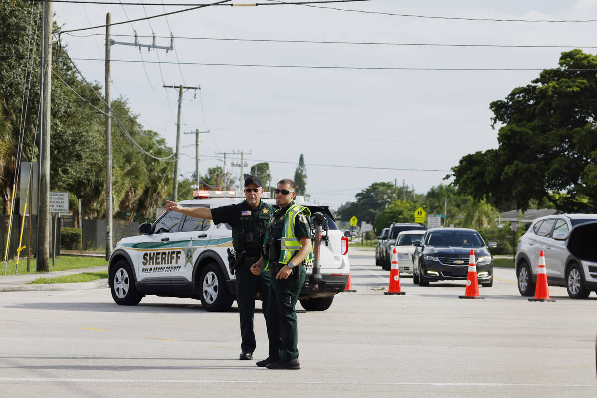 Police officers direct traffic near Trump International Golf Club after the apparent assassinat ...