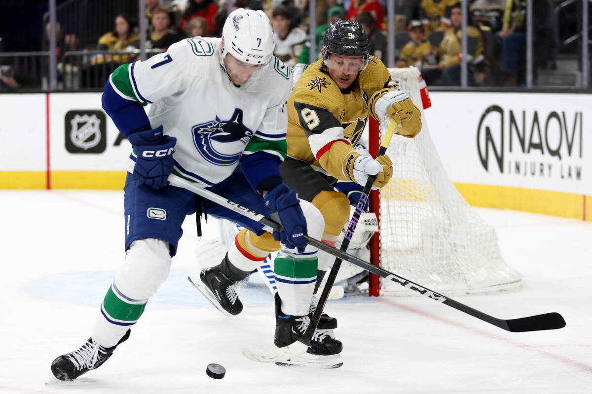 Golden Knights center Jack Eichel (9) battles for the puck against Canucks defenseman Carson So ...