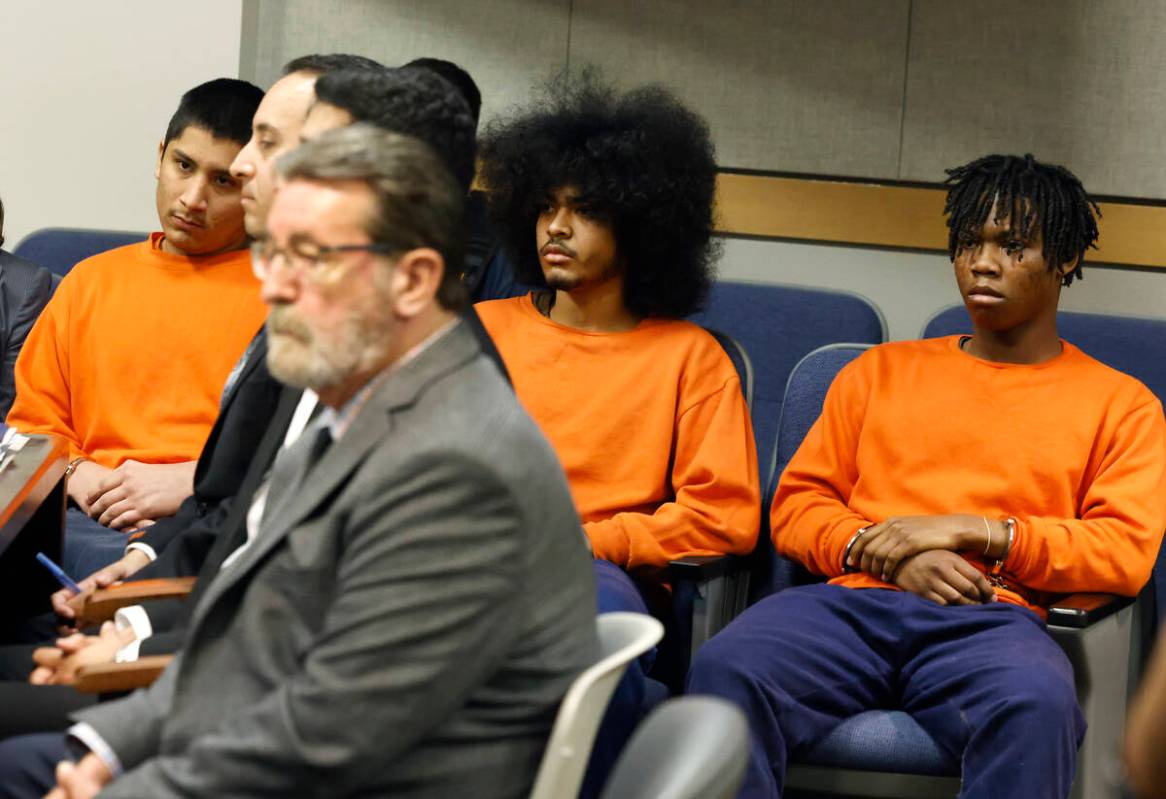 Damien Hernandez, left, Treavion Randolph and Dontral Beaver, right, all in orange prison sweat ...