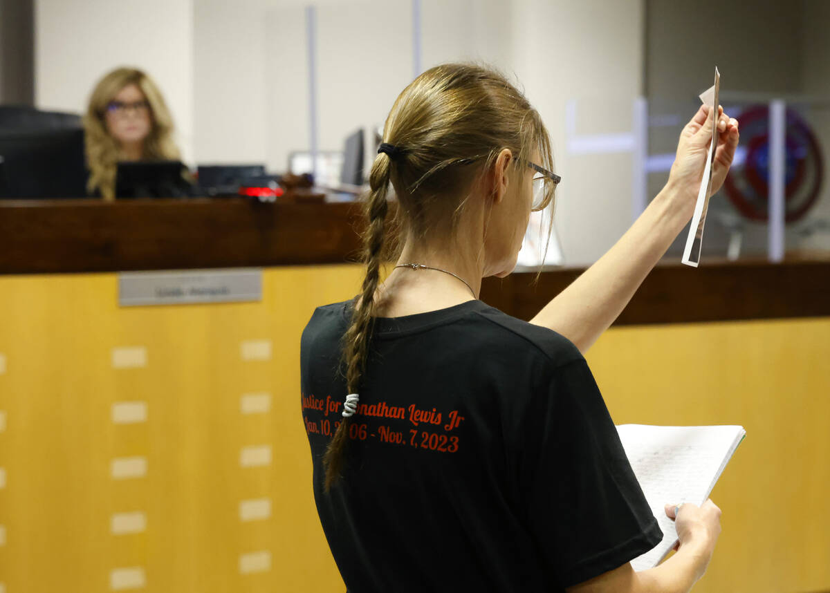 Mellisa Ready, the mother of Jonathan Lewis, wearing a "Justice for Jonathan" T-shirt, holds a ...