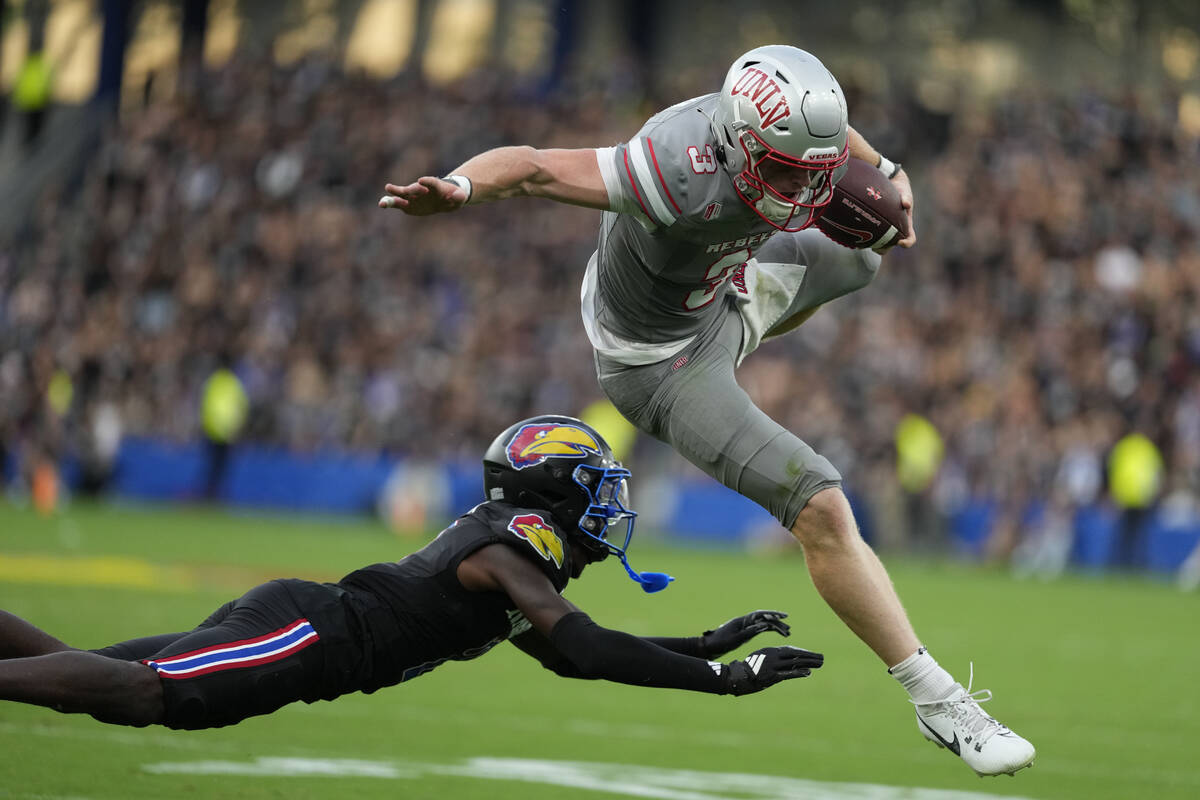 UNLV quarterback Matthew Sluka (3) leaps past Kansas cornerback Cobee Bryant (2) as he runs wit ...