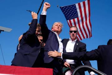 Republican presidential candidate former President Donald Trump gestures as he is surrounded by ...