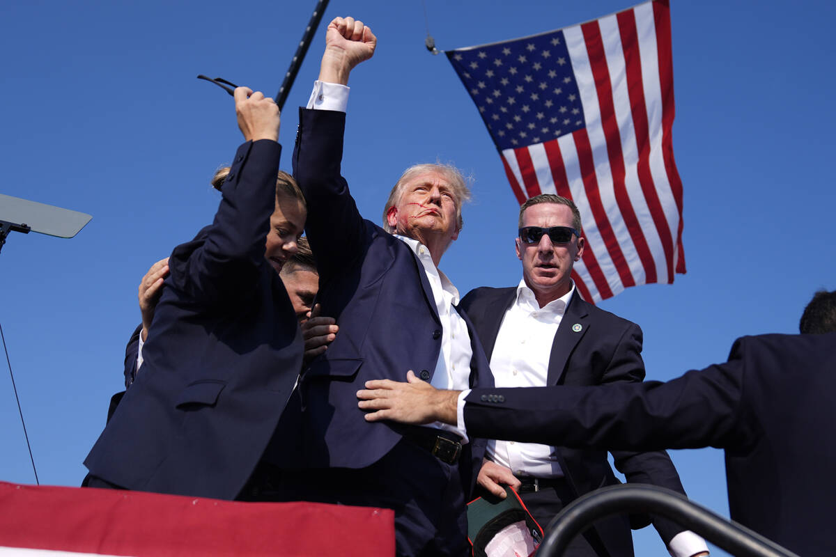 Republican presidential candidate former President Donald Trump gestures as he is surrounded by ...