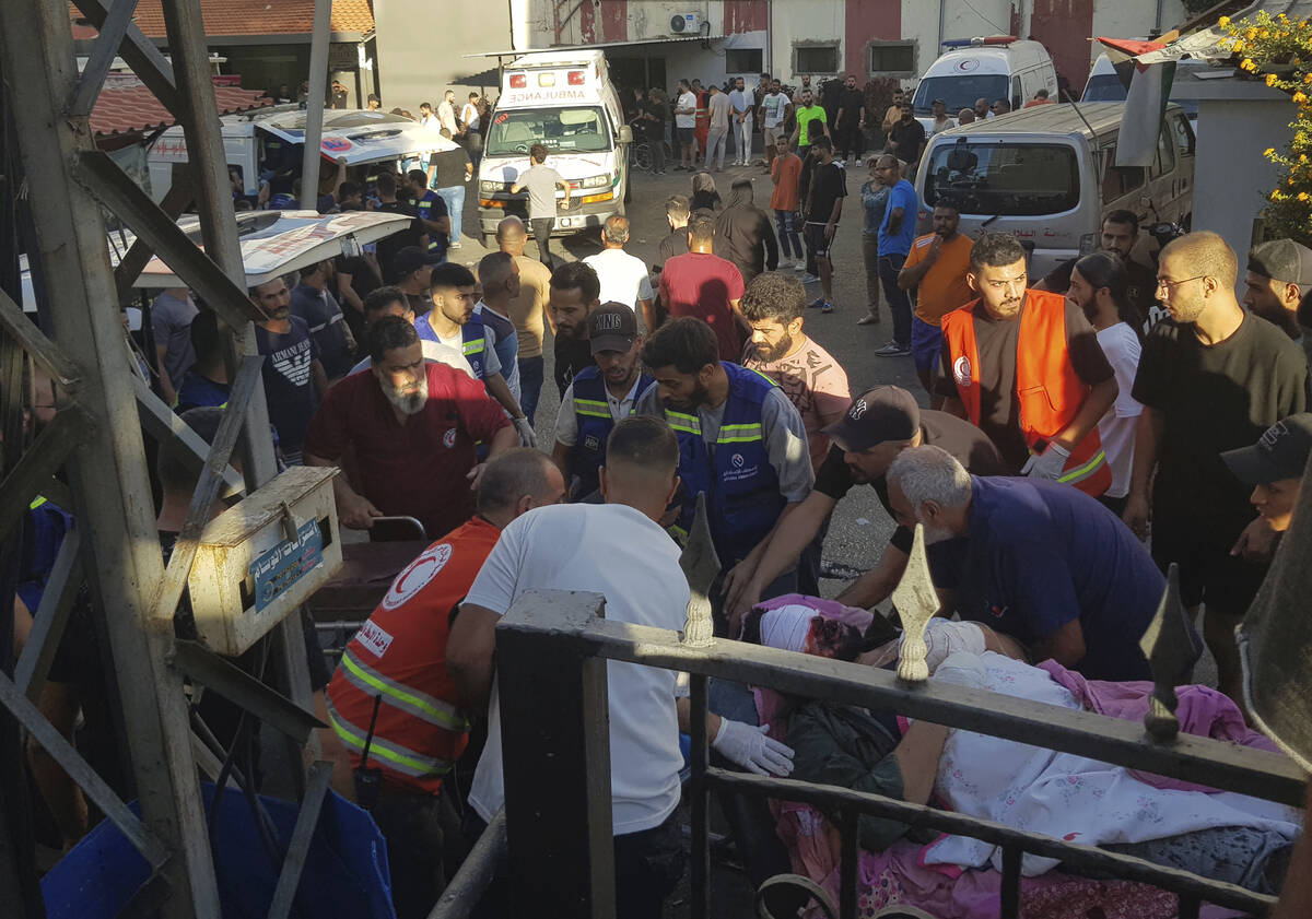 Civil Defense first-responders carry a man who was wounded after his handheld pager exploded, i ...