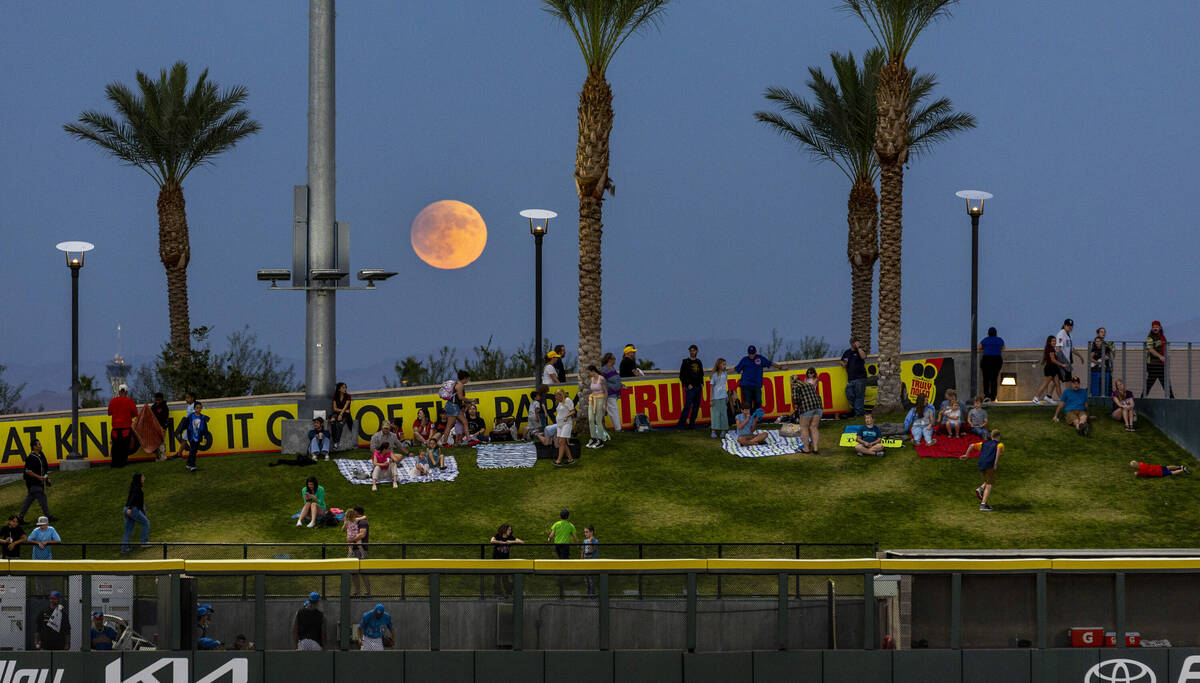 A Harvest Supermoon rises as fans gather on the berm for the Aviators against the El Paso Chihu ...