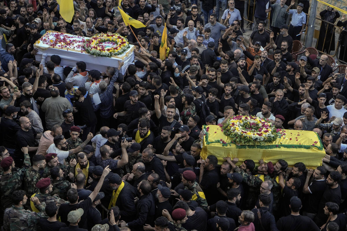 Mourners carry the coffins of victims who were killed Tuesday after their handheld pagers explo ...