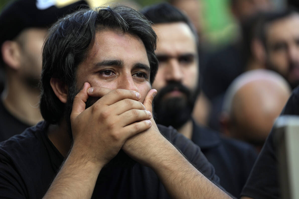 A man mourns during the funeral procession of two Hezbollah members, killed on Wednesday when a ...