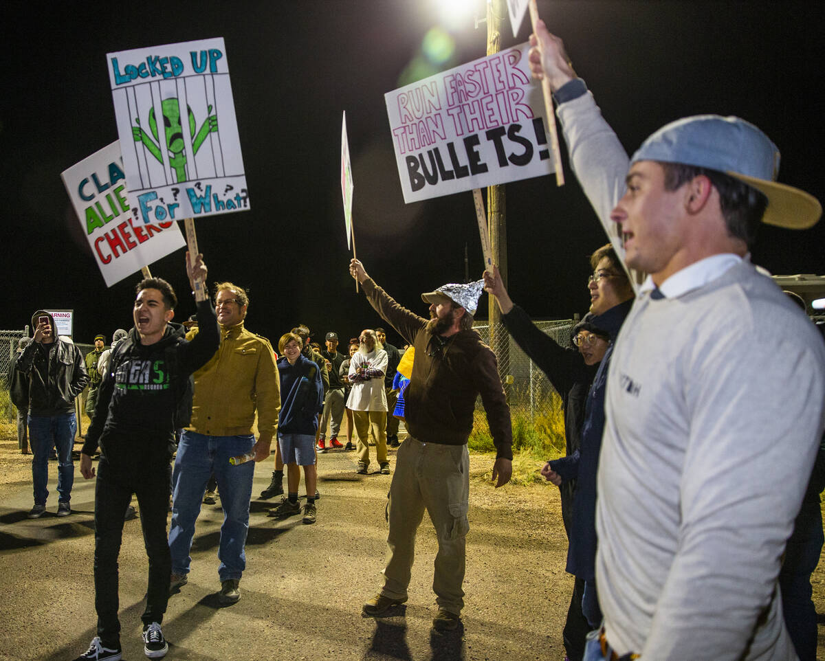 Individuals chant with signs in hand outside the back gate of Area 51 in homage to the original ...