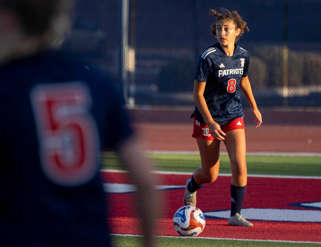 Liberty junior Amira Walker (8) looks to pass the ball during the high school soccer game again ...