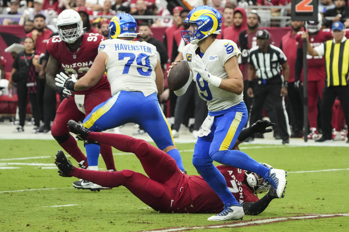 Los Angeles Rams quarterback Matthew Stafford (9) runs away from Arizona Cardinals linebacker K ...