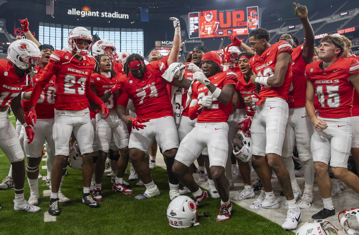 UNLV players celebrate their 72-14 win over Utah Tech with the UNLV Star of Nevada Marching Ban ...