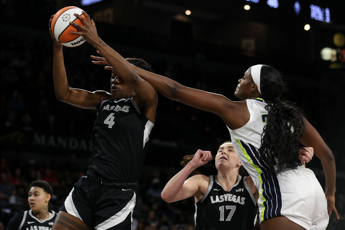 Las Vegas Aces center Queen Egbo (4) snags a rebound over Dallas Wings center Kalani Brown (21) ...