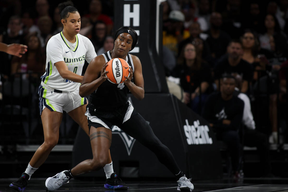 Las Vegas Aces center Queen Egbo (4) maneuvers the ball against Dallas Wings forward Satou Saba ...