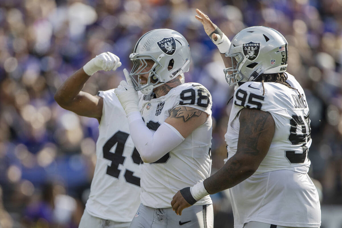 Raiders defensive end Maxx Crosby (98) motions for silence after sacking Baltimore Ravens quart ...