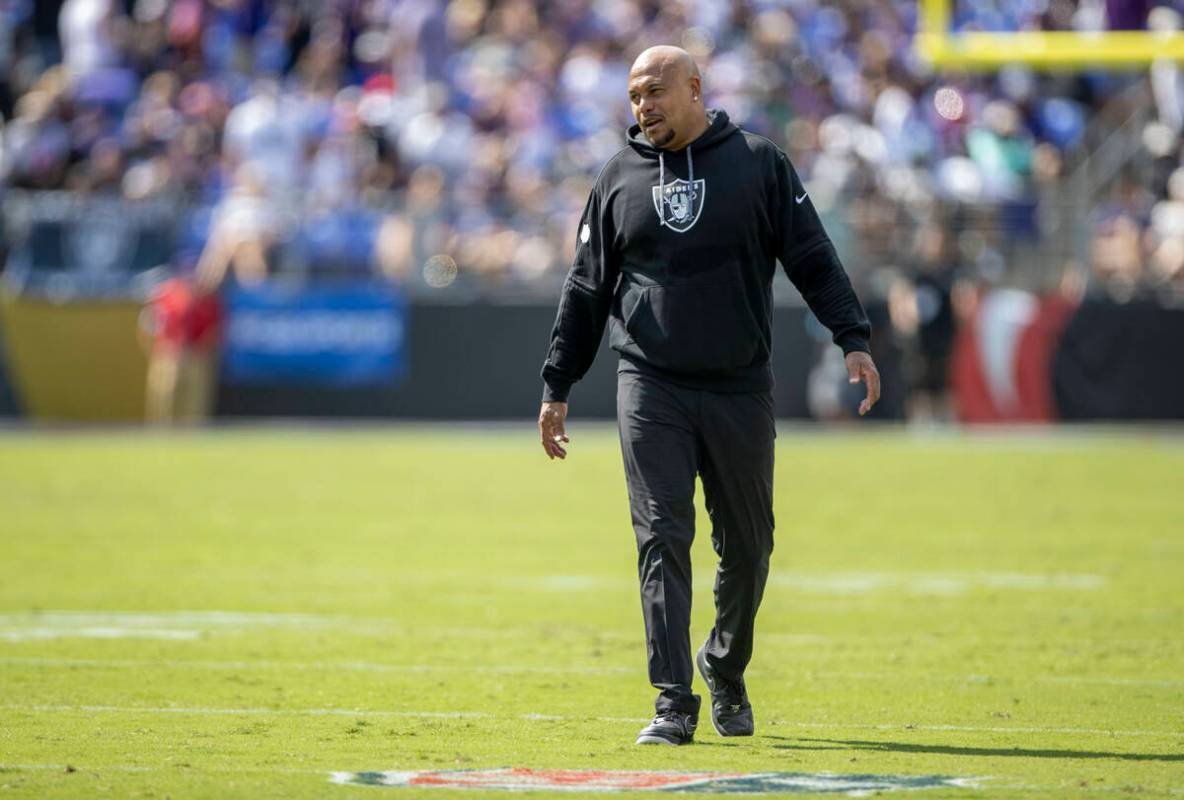 Raiders head coach Antonio Pierce smiles as he walks the field during the first half of an NFL ...