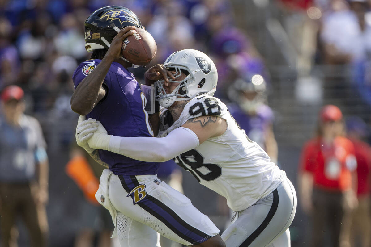 Raiders defensive end Maxx Crosby (98) sacks Baltimore Ravens quarterback Lamar Jackson (8) dur ...