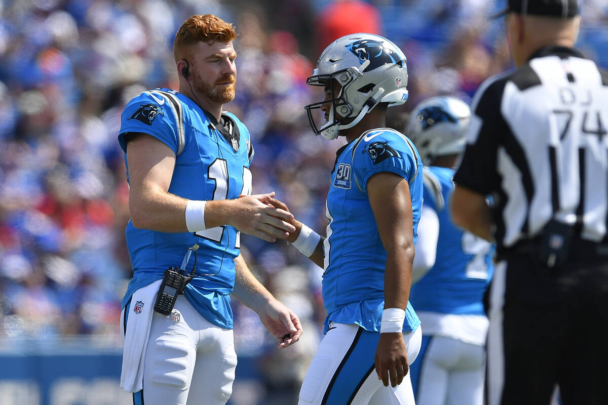 Carolina Panthers quarterback Andy Dalton, left, greets quarterback Bryce Young as he walks off ...