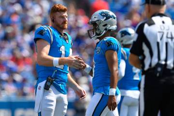 Carolina Panthers quarterback Andy Dalton, left, greets quarterback Bryce Young as he walks off ...