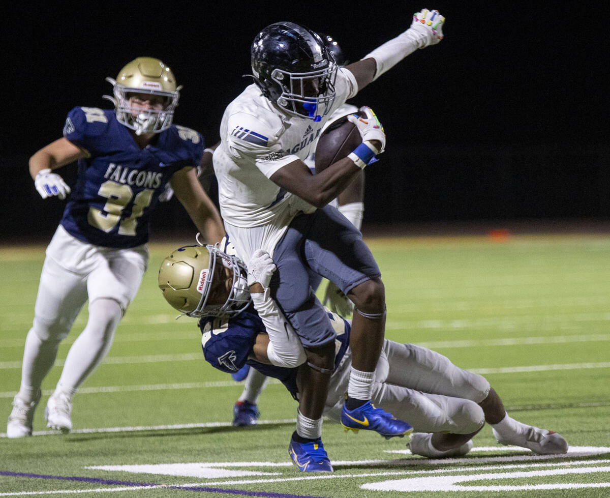 Foothill cornerback Isaiah Sams (20) slowly brings down Desert Pines senior Ejuan Carter (1) du ...