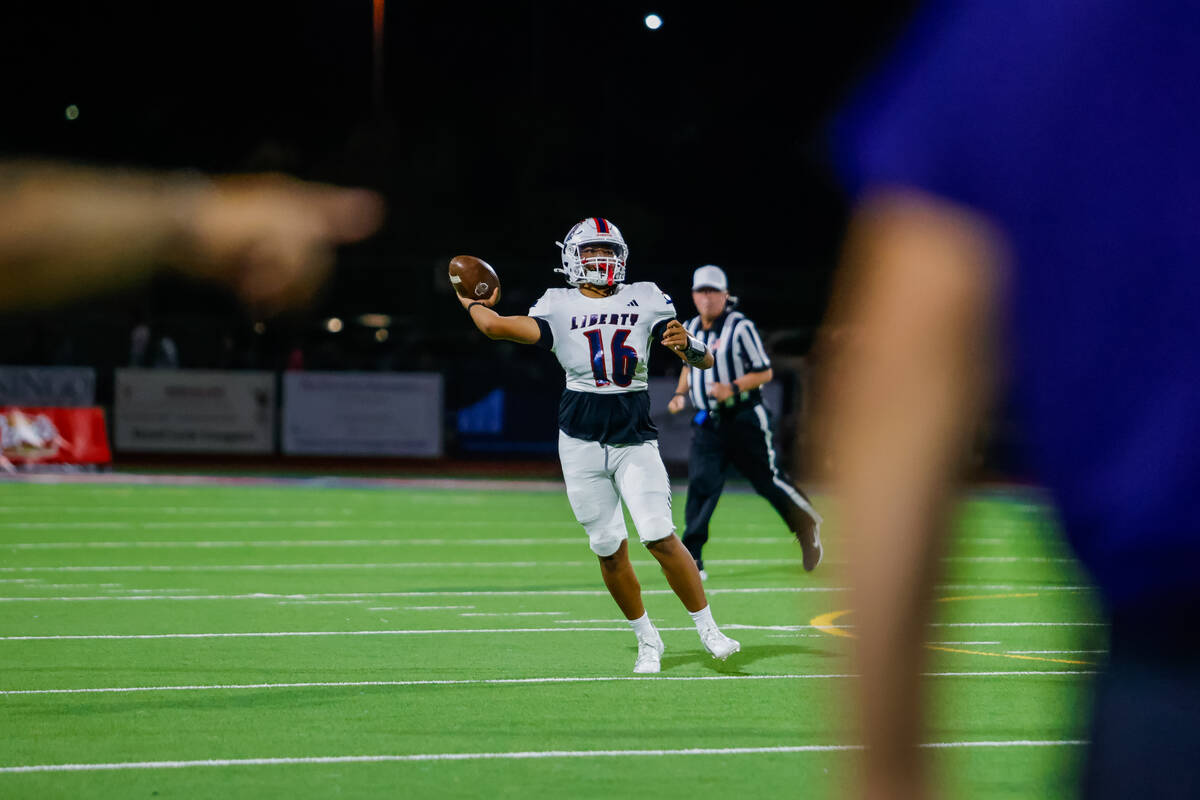 Liberty Quarterback Troy Kan (16) throws the ball down the field during a football game between ...