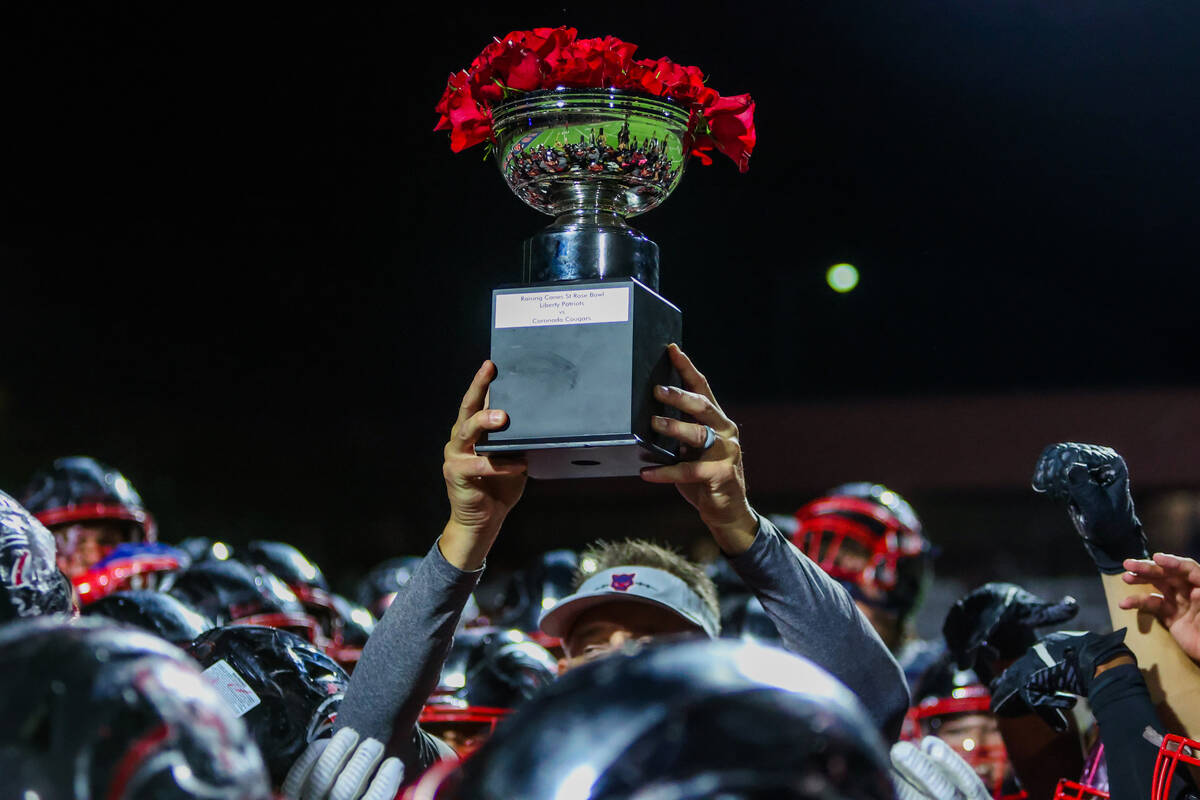 The St. Rose bowl trophy is hoisted in a Coronado huddle following a football game between Libe ...