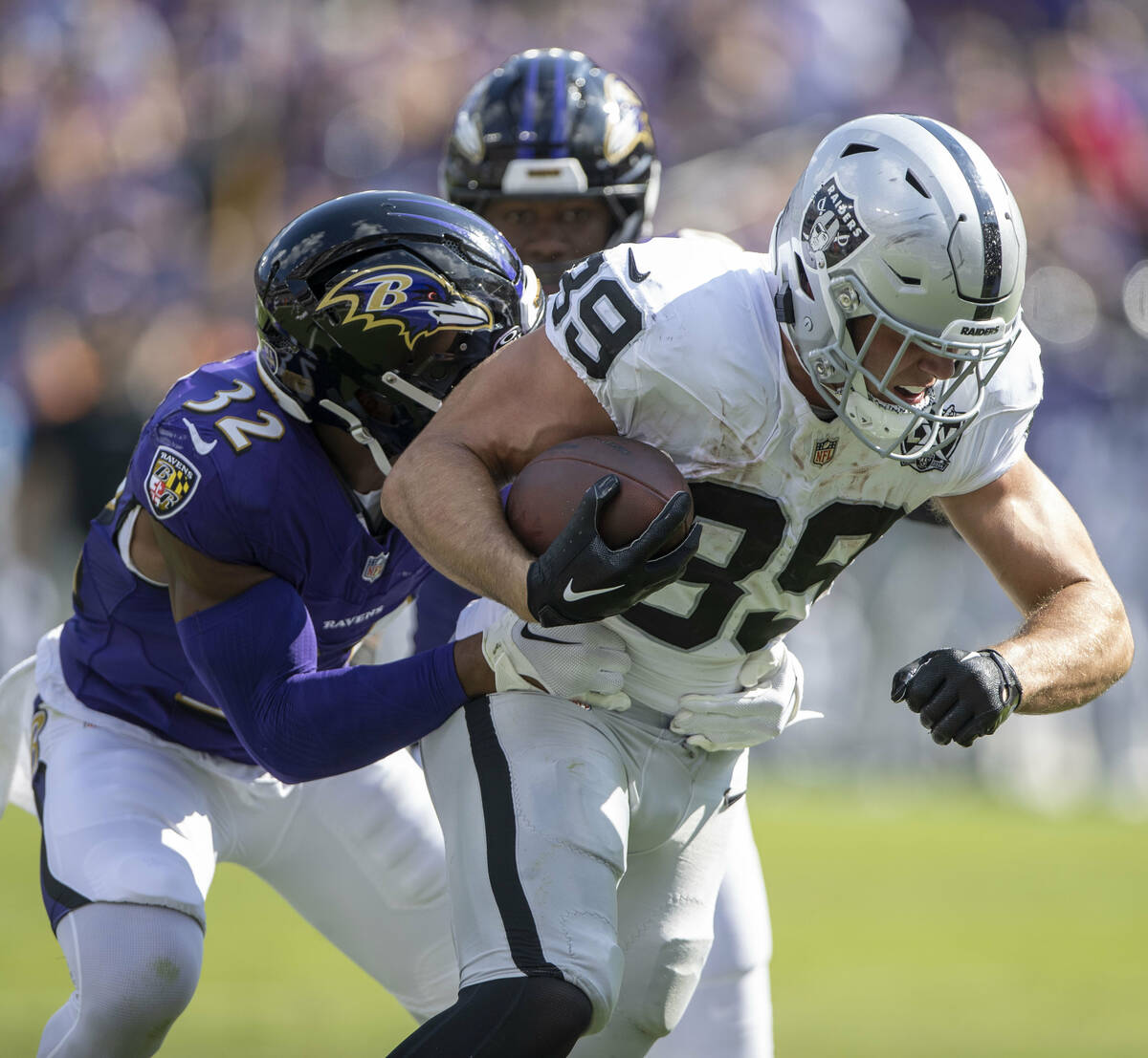 Raiders tight end Brock Bowers (89) fights for more yards with Baltimore Ravens safety Marcus W ...