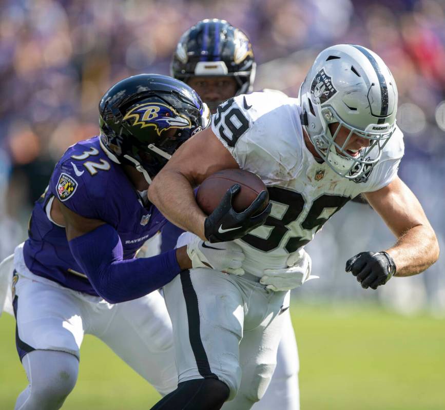 Raiders tight end Brock Bowers (89) fights for more yards with Baltimore Ravens safety Marcus W ...