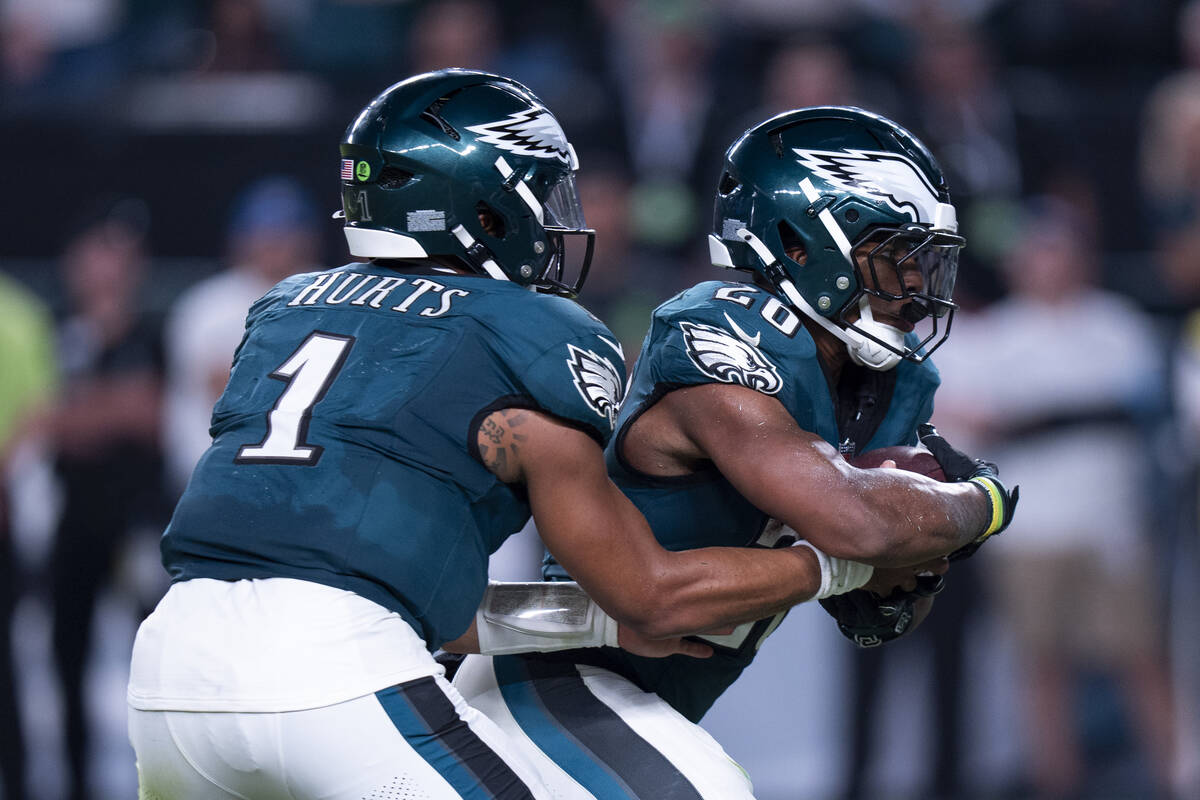 Philadelphia Eagles running back Saquon Barkley (26) takes the hand off from quarterback Jalen ...