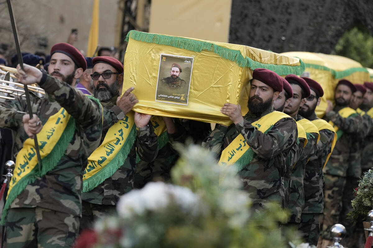 Hezbollah fighters carry the coffins of their comrades who were killed in Friday's Israeli stri ...