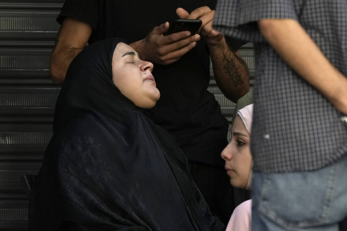 Relatives of the victims react near the site of Friday's Israeli strike in Beirut's southern su ...