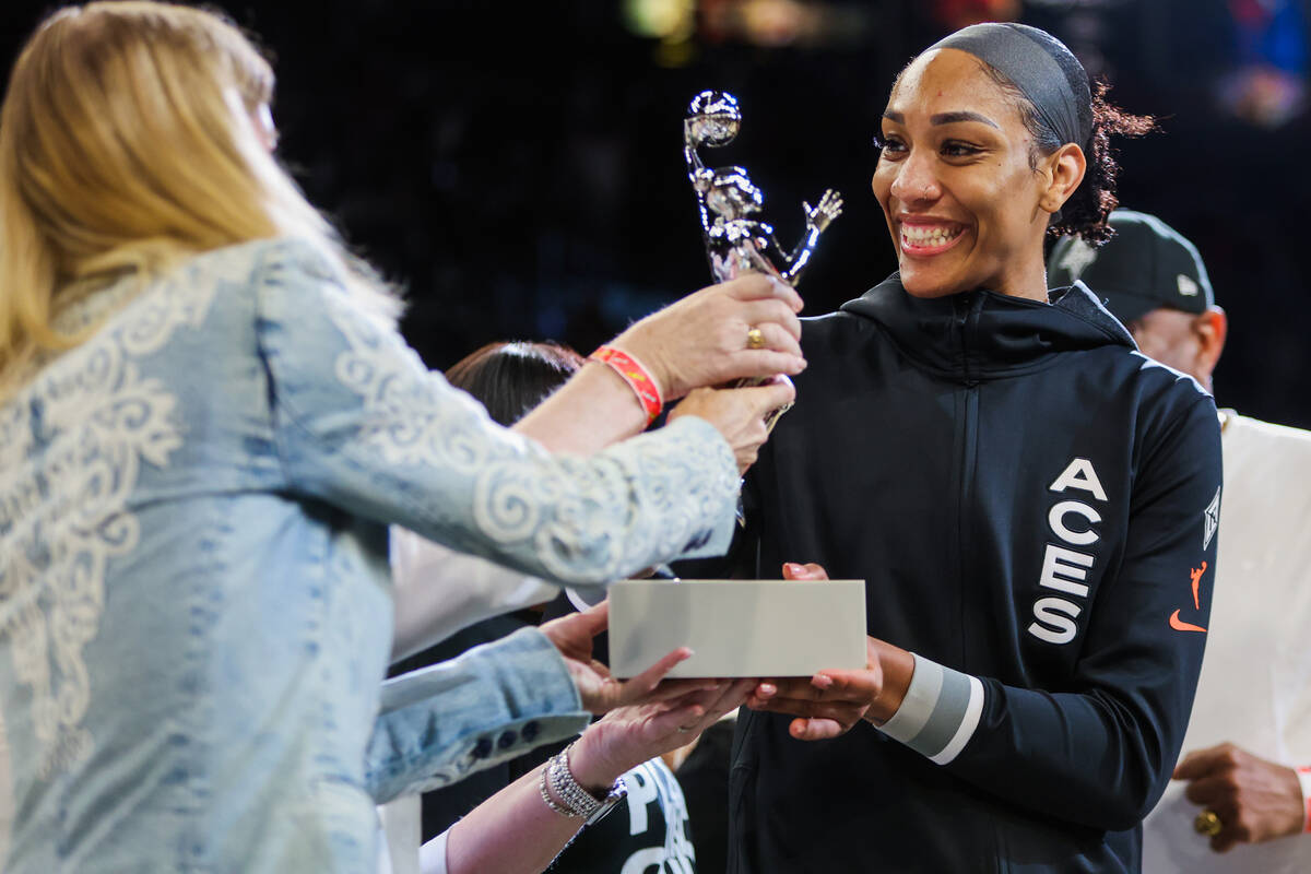 Aces center A'ja Wilson is presented with the WNBA MVP trophy before game one of a WNBA playoff ...