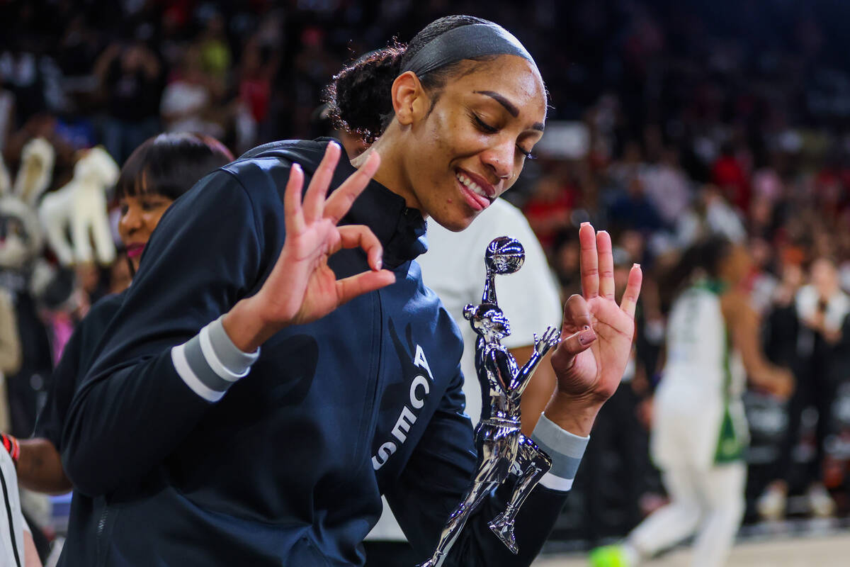 Aces center A'ja Wilson poses with her WNBA MVP trophy before game one of a WNBA playoff game b ...