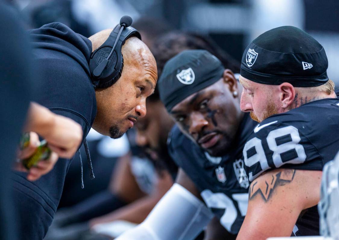 Raiders Head Coach Antonio Pierce (hc) checks in on defensive end Maxx Crosby (98) after being ...