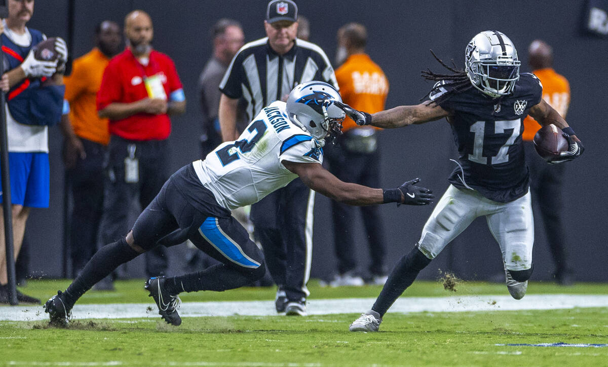 Raiders wide receiver Davante Adams (17) evades a tackle attempt by Carolina Panthers cornerbac ...