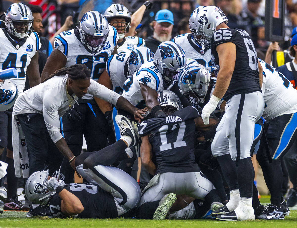 Raiders wide receiver Davante Adams (17) is swarmed on by Carolina Panthers players during the ...