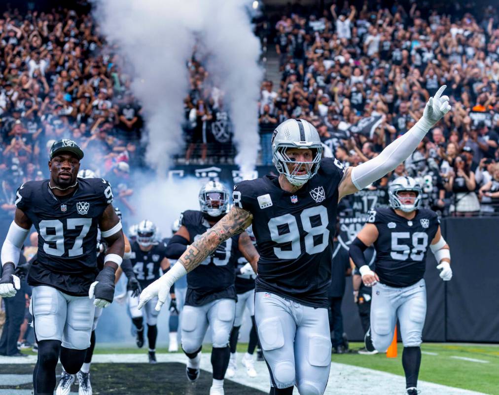 Raiders defensive end Maxx Crosby (98) leads his teammates onto the field before the first half ...