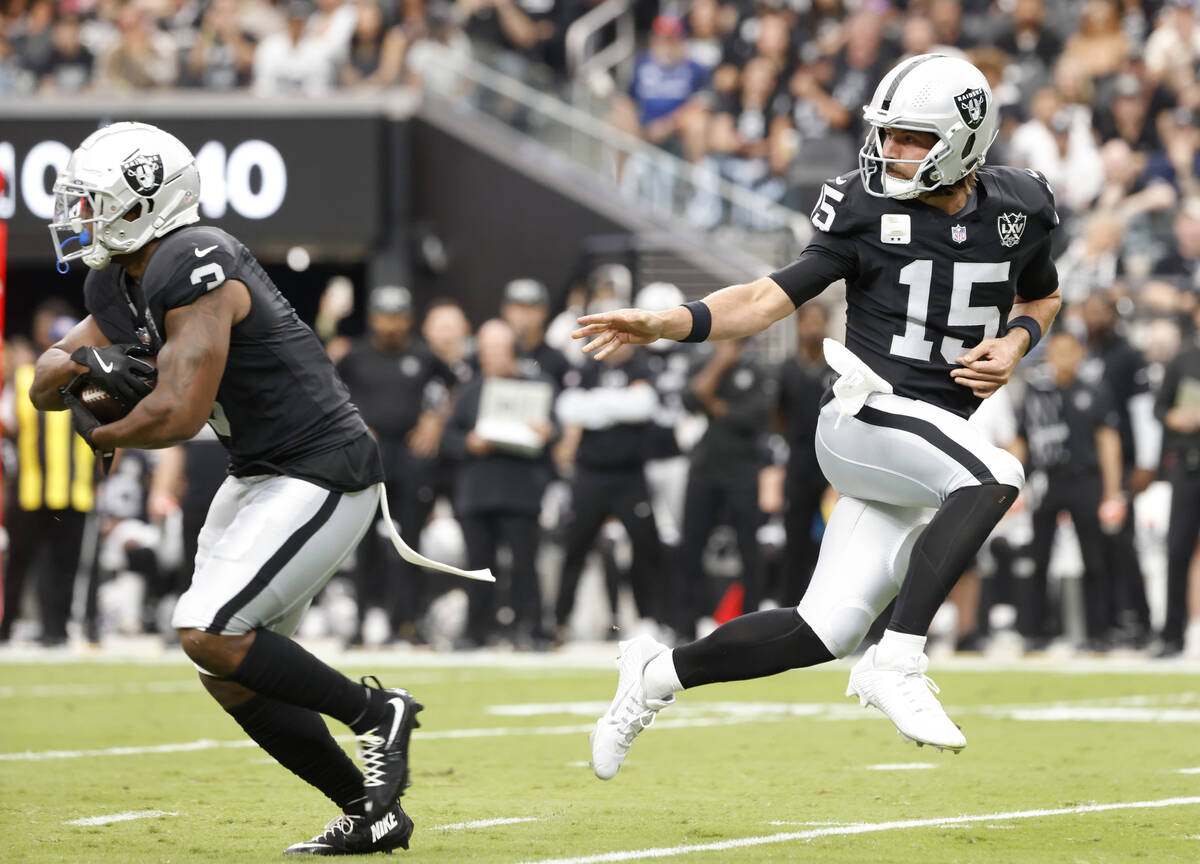 Raiders quarterback Gardner Minshew (15) hands off to running back Zamir White (3) during the f ...