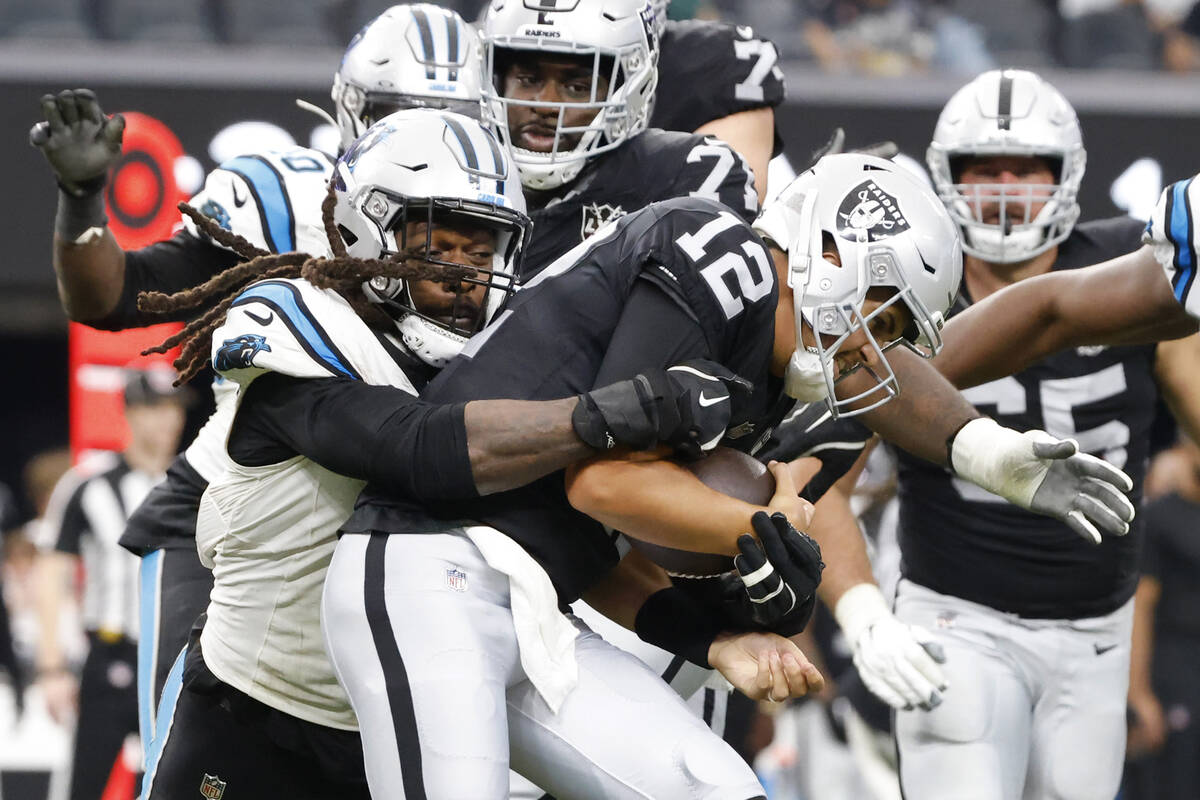 Raiders quarterback Aidan O'Connell (12) is sacked by Carolina Panthers linebacker Jadeveon Clo ...