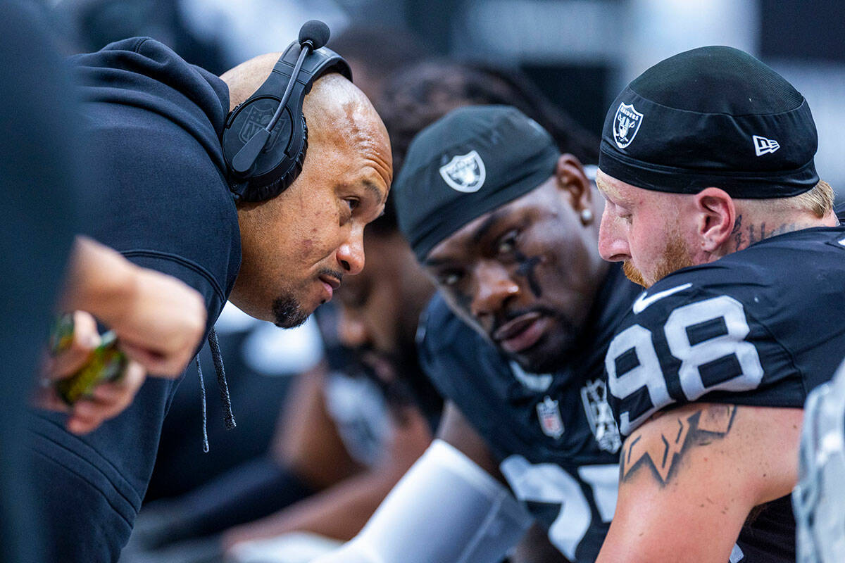 Raiders Head Coach Antonio Pierce (hc) checks in on defensive end Maxx Crosby (98) after being ...