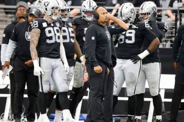 Raiders head coach Antonio Pierce, center, defensive end Maxx Crosby (98), defensive tackle Joh ...