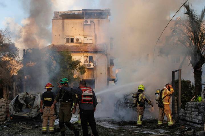 Israeli security and rescue forces work at the site hit by a rocket fired from Lebanon, in Kiry ...