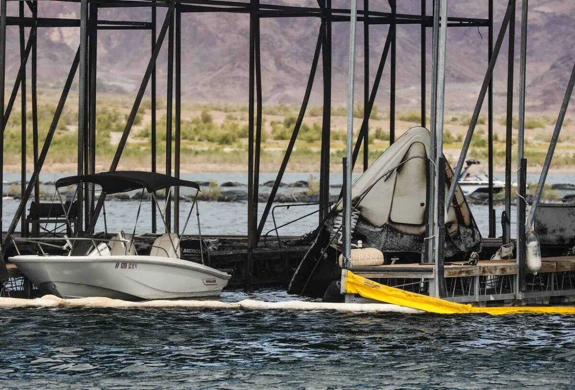 The bow of a sunken boat peaking out of the water at the scene where a fire sank 10 boats, did ...