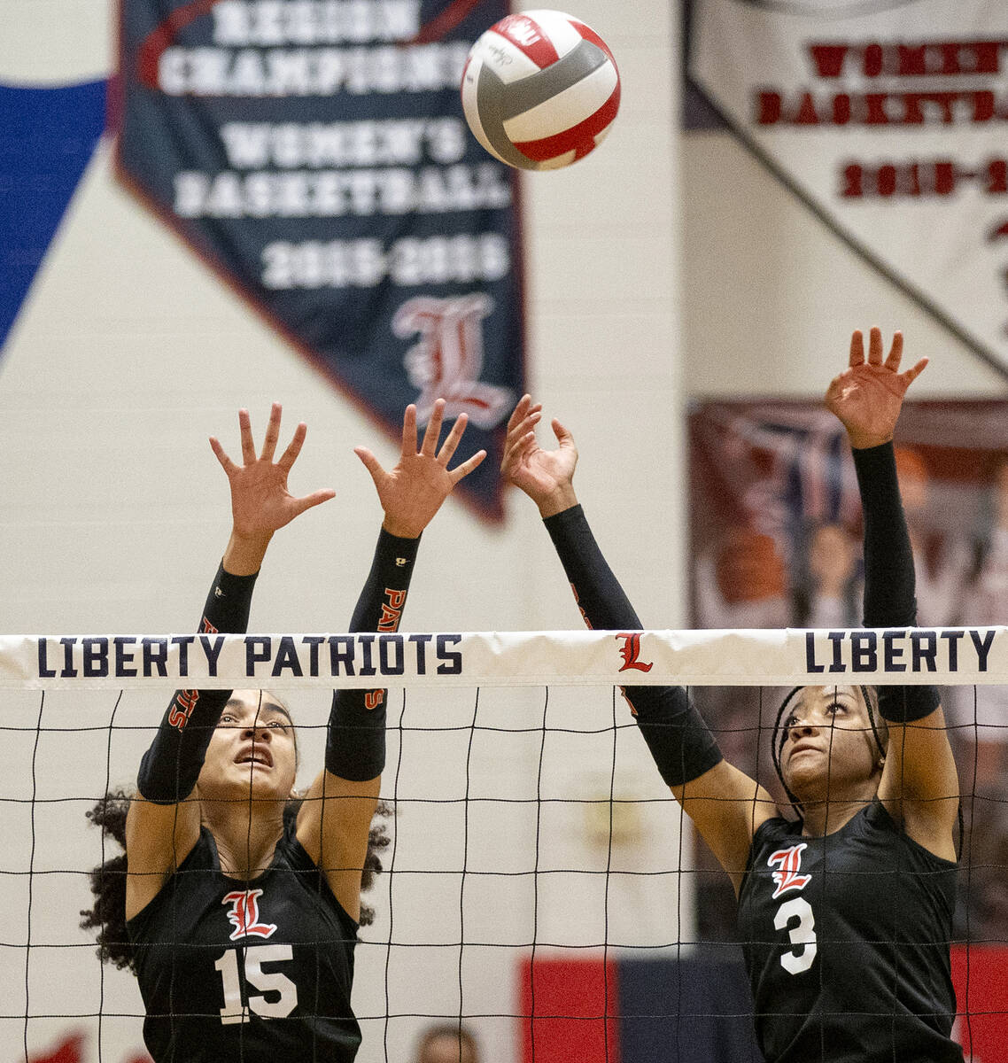 Liberty junior Maia Greer (15) and senior Kennedy Cooper (3) attempt to block the ball during t ...